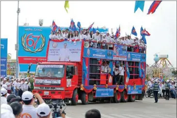  ?? HENG CHIVOAN ?? CPP supporters greet potential voters from a bus on July 7, during the kickoff to the campaign period for this month’s national elections .