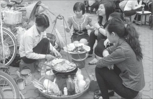  ?? LINDA DEVITT/ SPECIAL TO THE SUN ?? Vendors cooking on the streets of Hanoi.