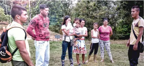  ??  ?? Molina talks to members of his community at Puerto Las Palmas village. Since January, he has received 22 threats by illegal armed groups.