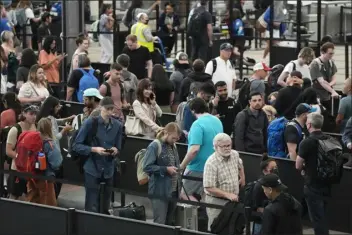  ?? DAVID ZALUBOWSKI — THE ASSOCIATED PRESS ?? Travelers wait in long lines at a security checkpoint in Denver Internatio­nal Airport Tuesday in Denver. The Fourth of July holiday weekend jammed U.S. airports with the biggest crowds since the pandemic began in 2020.