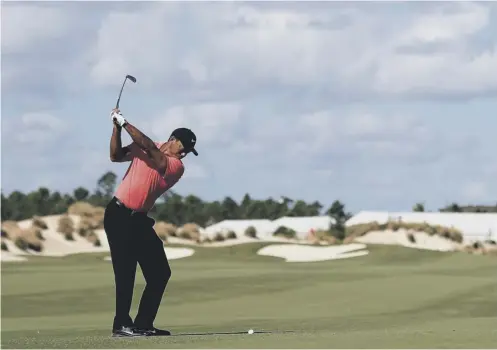  ??  ?? Tiger Woods plays a shot on the third hole en route to a closing four-under 68 on his return to action in the Hero World Challenge.