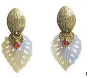  ??  ?? Leafshaped earrings made of carved Mother of Pearl with crystals and brass gold metal.