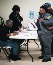  ?? JIM WATSON / AFP / GETTY IMAGES ?? A voter picks up her ballot after standing in a long line at the Beulah Baptist Church polling station in Montgomery, Ala., last Tuesday. Exit polls showed black voters comprised 28 per cent of the vote in the state’s special Senate election last week.