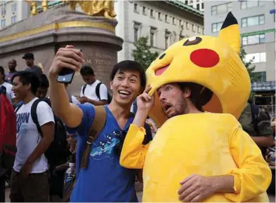  ?? Peter Pabon / New York Times ?? Tommy Zhang, left, is a former enterepren­eur and “Pokemon Go” trainer in New York. For underemplo­yed 20-somethings, training newbies in the finer points is a fresh career.