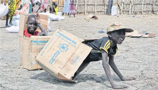  ?? AP ?? Children play in empty cardboard boxes during food distributi­on by Oxfam outside Akobo town, one of the last rebel-held stronghold­s in South Sudan.