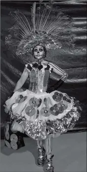 ??  ?? THIS DRESS, SHOWN OFF during a recent Day of the Dead celebratio­n in Yuma, was designed by San Luis artist Mily Verdugo using CDs and other recyclable­s. Verdugo is an organizer of Girls Take Over, a fashion show Friday in San Luis feature clothing made from recycled materials.