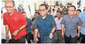  ?? — Bernama ?? Taking it in their stride: Khaled (in blue) and other state Barisan officials arriving for a press conference in Johor Baru.