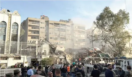  ?? ?? Emergency and security personnel gather at the site of strikes which hit a building adjacent to the Iranian embassy in Damascus.