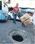  ?? FOTO: JIMMY ARGUETA ?? Vendedores pasan con zozobra al lado del agujero en la calle.