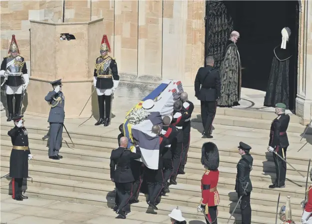  ??  ?? 0 The Duke of Edinburgh’s coffin, covered with His Royal Highness’s Personal Standard, arrives at St George’s Chapel carried by a bearer party of Royal Marines