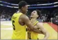  ?? GERRY BROOME — ASSOCIATED PRESS ?? UMBC’s K.J. Maura (11) and Jourdan Grant (5) celebrate the team’s 74-54 win over Virginia in a first-round game in Charlotte, N.C., Friday.