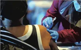  ?? JON LANGHAM/BEACON-NEWS ?? A woman gets inoculated at the mass vaccinatio­n clinic Tuesday at the Cathedral of Grace St. John AME Church in Aurora. A site in Des Plaines is scheduled to open Thursday.