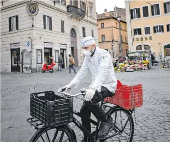  ?? FOTO: ALBERTO PIZZOLI/AFP ?? Ein Koch auf dem zentralen – und wegen des Coronaviru­s fast menschenle­eren – Platz Campo de’ Fiori in Rom.