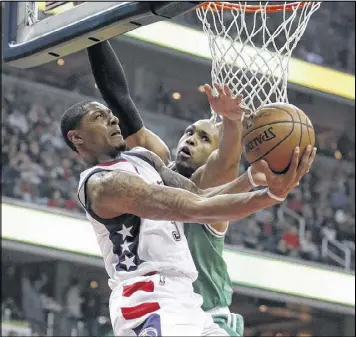  ?? ALEX BRANDON / AP ?? Guard Bradley Beal, who led the Wizards with 33 points, goes under the basket for a shot to avoid the defense of Celtics center Al Horford in Game 6.