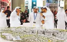  ?? Abdul Rahman/Gulf News ?? Talal Al Dhiyebi (right), CEO of Aldar, showing the model of the Al Ghadeer project at the company’s pavilion.