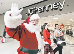  ?? Damian Dovarganes, AP ?? Santa Claus greets shoppers lastweek outside a J.C. Penney store in Glendale, Calif. Penney’s needs a strong holiday season to stem losses.