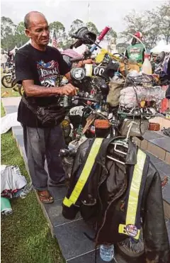  ??  ?? ISHAK menunggang motosikal bersama peralatan untuk mencuci masjid.