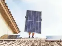  ?? TOM TINGLE/THE REPUBLIC ?? Chris Miller, a solar panel installer for SunHarvest Solar, installs panels on a home in El Mirage in November.