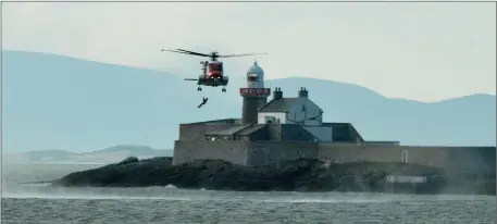  ?? Photos by Domnick Walsh Eye Focus ?? A member of the Fenit Lifeboat Crew is winched from the water near Fenit Lighthouse by the Irish Coast Guard search and rescue helicpoter during an exercise on Sunday.