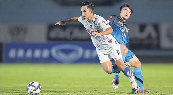  ??  ?? Bangkok United’s Sumanya Purisai, left, in action against Air Force last night.