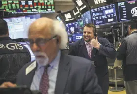  ?? Drew Angerer / Getty Images ?? Monday was a busy and happy day on the New York Stock Exchange, as the Dow Jones industrial average rose nearly 670 points.