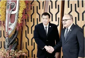  ?? AP FOTO ?? SEALED WITH A HANDSHAKE. President Rodrigo Duterte (left) is greeted by Papua New Guinea Prime Minister Peter O’Neill at the start of the Apec Economic Leaders’ Meeting.