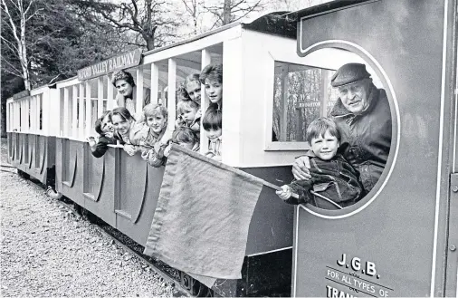  ??  ?? THE TRAIN NOW STANDING: Neil Morrison, four, of Aberdeen helps driver Gibby Reid to flag off the holiday special on a trip through the Haughton Park Estate near Alford in May 1986