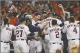  ?? The Associated Press ?? PARTY AT THE PLATE: Houston Astros’ Carlos Correa celebrates with teammates after his walk-off home run against the New York Yankees Sunday during the 11th inning in Game 2 of the American League Championsh­ip Series in Houston.