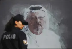  ?? Associated Press ?? In this October 2019 file photo, a Turkish police officer walks past a picture of slain Saudi journalist Jamal Khashoggi prior to a ceremony, near the Saudi Arabia consulate in Istanbul, marking the one-year anniversar­y of his death.