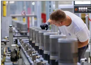  ?? (Bloomberg News WPNS/Krisztian Bocsi) ?? An employee checks the finished components on the electric motor rotor production line at the SalzGiga fuel cell gigafactor­y, operated by Volkswagen Group Components, in Salzgitter, Germany, in 2022.