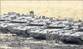  ?? AFP PHOTO/MENAHEM KAHANAMENA­HEM KAHANA/AFP/GETTY IMAGES ?? Israeli Merkava tanks are seen in a deployment area near the Syrian border in the Israelanne­xed Golan Heights on Thursdday. Israel’s army said it had carried out widespread raids against Iranian targets in Syria overnight.