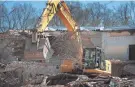  ??  ?? Demolition specialist­s clear debris from the north side of the old Colliervil­le High School building.