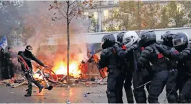  ?? REUTERS ?? French CRS riot police face off with protesters during clashes at a demonstrat­ion against French government’s pensions reform plans in Paris as part of a day of national strike and protests in France.