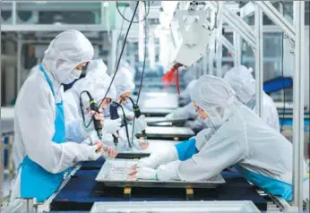  ?? XINHUA ?? Workers assemble television sets at a Hisense Group plant in Qingdao, Shandong province. The consumer electronic­s maker is banking on sports event to increase its global exposure.