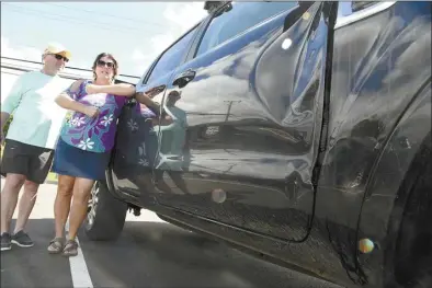  ?? The Maui News / MATTHEW THAYER photo ?? Alysha Nichols-Sparkman stands next to husband Sidney Sparkman and his damaged truck Friday afternoon in Kula while describing Wednesday’s carjacking in Pukalani.