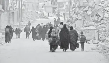  ??  ?? Syrian civilians flee the Sukkari neighbourh­ood towards safer rebel-held areas in southeaste­rn Aleppo.