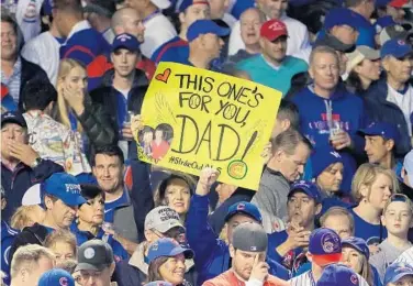  ?? JAMIE SQUIRE/GETTY IMAGES ?? A Chicago fan holds a sign that hearkens back to Cubs history during Game 3 of the World Series at Wrigley Field on Friday.