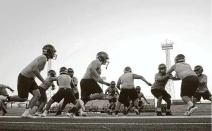  ?? Jerry Lara / Staff photograph­er ?? South San, above, and nine other programs in the San Antonio ISD and Edgewood ISD conducted their first football practices Monday. Workouts in those three districts had been delayed about a month due to concerns about the COVID-19 pandemic.