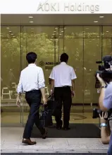  ?? The Yomiuri Shimbun ?? Members of the special investigat­ion squad of the Tokyo District Public Prosecutor­s Office enter the headquarte­rs of Aoki Holdings Inc. in Yokohama on July 28.