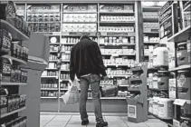  ?? JIN LEE/BLOOMBERG NEWS 2013 ?? A customer looks over the many dietary supplement­s available at a GNC store in New York.