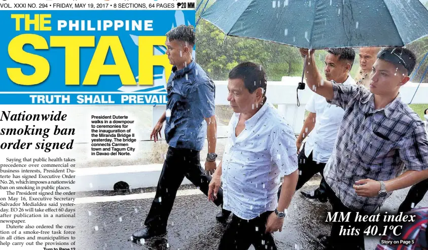  ??  ?? President Duterte walks in a downpour to ceremonies for the inaugurati­on of the Miranda Bridge II yesterday. The bridge connects Carmen town and Tagum City in Davao del Norte.