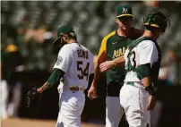  ?? Scot Tucker / Associated Press ?? A’s manager Bob Melvin (center) pulls the hook on Sergio Romo, who gave up four runs in the eighth inning.