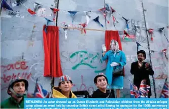  ??  ?? BETHLEHEM: An actor dressed up as Queen Elizabeth and Palestinia­n children from the Al-Aida refugee camp attend an event held by secretive British street artist Banksy to apologize for the 100th anniversar­y of the Balfour Declaratio­n. The queen...