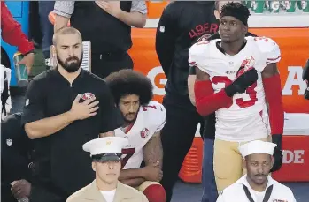  ?? THE ASSOCIATED PRESS ?? San Francisco 49ers quarterbac­k Colin Kaepernick, centre, kneels during the U.S. national anthem before the team’s NFL pre-season game against the San Diego Chargers on Thursday in San Diego.