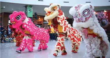  ?? FIRMA ZUHDI/JAWA POS ?? SEMARAK: Pengunjung Lippo Plaza melihat barongsai kemarin. Foto kiri, pengurus Kelenteng Tjong Hok Kiong menyalakan kembang api.