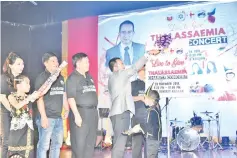  ??  ?? Azhar (right) cutting the ribbon to mark the launch of the Thalassemi­a Charity Concert.