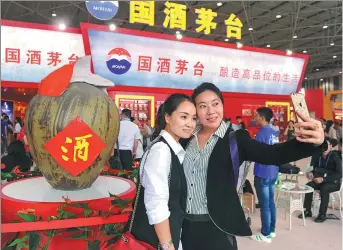  ?? CHINA NEWS SERVICE ?? Two visitors take a selfie in front of a huge wine jar at the Kweichow Moutai exhibition stand, at the 2016 China (Guizhou) Internatio­nal Wine Exposition, held in Guiyang, Guizhou province.