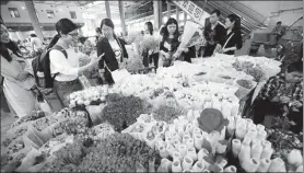  ?? YANG ZHENG / FOR CHINA DAILY ?? A female consumer scans a QR code using her smartphone, to pay for flowers she selected in a flower market in Kunming, Yunnan province.