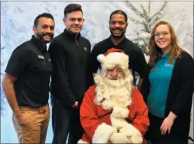  ??  ?? The UPS Store staff visits with Santa.