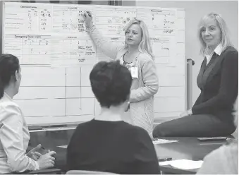  ?? NICK BRANCACCIO ?? Marie Lachapelle, manager utilizatio­n command, standing at left, and Theresa Morris, director of emergency services, listen to other directors during a patient-flow discussion in the command centre at Windsor Regional Hospital’s Met campus on Thursday.